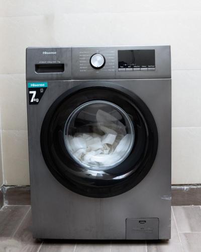 a washing machine with its door open in a room at Luxury 2BR Apartment with AC, Wi Fi, Backup Power Ideal for Families , Bukoto in Kampala