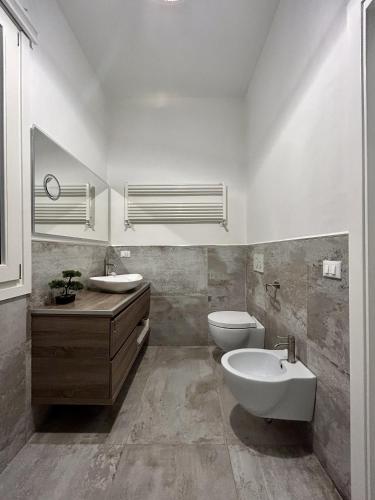 a bathroom with a toilet and a bidet and a sink at Tra Arte Amare in Pietrasanta