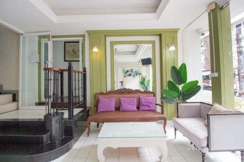 a living room with purple pillows on a couch at Skutan Inn Sutthisan Nexus Opal in Bangkok