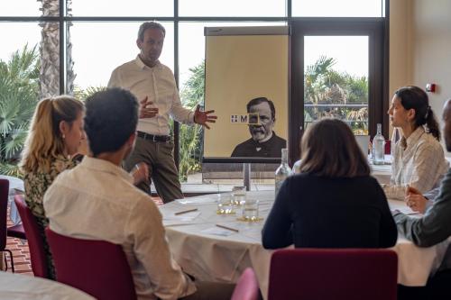 a man standing in front of a group of people sitting around a table at Hôtel Villa M Marseille in Marseille