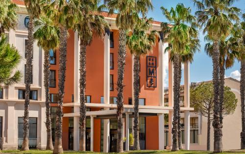 a building with palm trees in front of it at Hôtel Villa M Marseille in Marseille