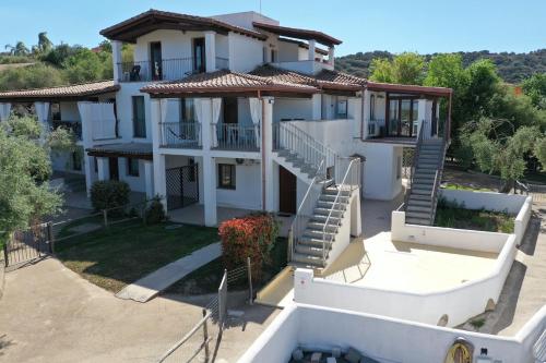 a large white house with stairs in front of it at Guido Holiday Home - Torre di Barì in Bari Sardo