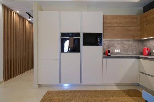 a kitchen with white cabinets and a microwave at Villa 1868 in Mithymna
