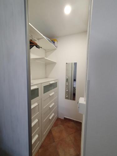 a walk in closet with white cabinets and a mirror at Guido Holiday Home - Torre di Barì in Bari Sardo