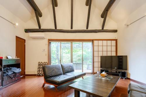 a living room with a couch and a tv at 楽宿 藤花 046h in Hakone