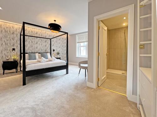a bedroom with a canopy bed and a walk in closet at Incredible Luxury Windsor Long Walk 4 Bedroom Home With Free Driveway Parking in Windsor
