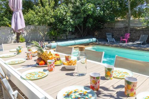 un tavolo con piatti di cibo accanto alla piscina di Villa Laurens Maison spacieuse avec piscine ad Agde