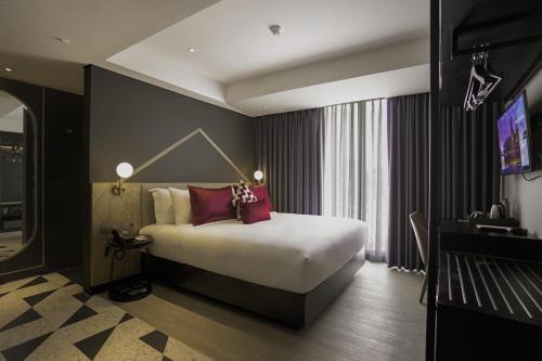 a hotel room with a bed and a television at Awann Sewu Boutique Hotel and Suite Semarang in Semarang