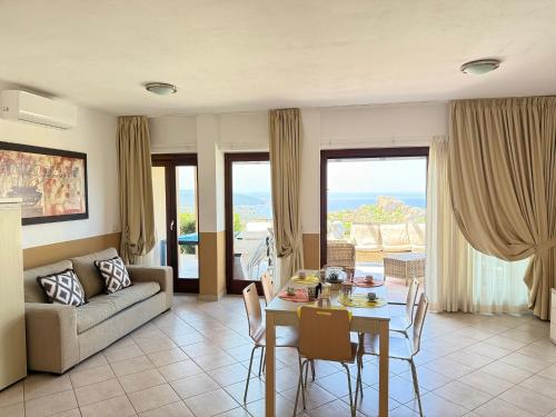 a living room with a couch and a table with chairs at Villa Blue Horizon in Costa Paradiso