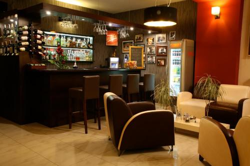 a bar in a restaurant with chairs and a counter at Hotel Seven 7 in Kalisz