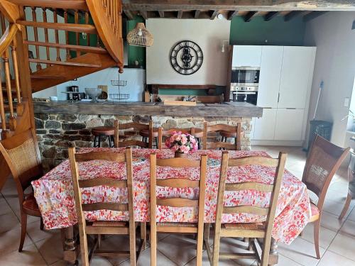 a dining room with a table and some chairs at Longère avec jacuzzi et jardin à 10 min de Rennes in Servon-sur-Vilaine