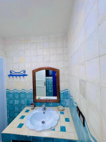 a bathroom with a sink and a mirror at Le petit château Vue sur mer Uniquement les familles in Oualidia