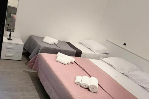 a room with two beds with towels on them at Hotel Bologna in Rimini