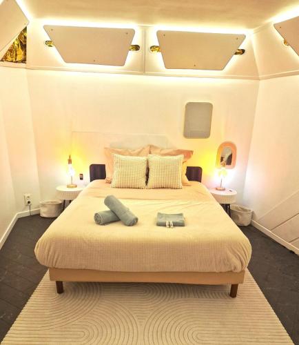 Un dormitorio con una cama grande con dos mesas. en Gite Urbain - Asclepios, en Épernay