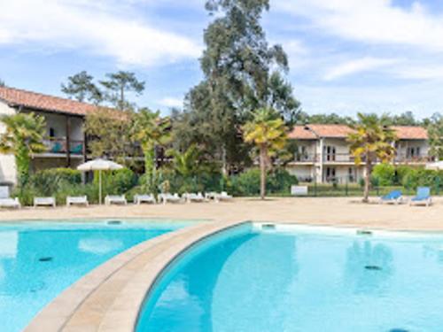 une grande piscine devant un complexe hôtelier dans l'établissement Appartement T4 avec Wi-Fi et parking dans résidence avec activités - FR-1-239-1125, à Ondres