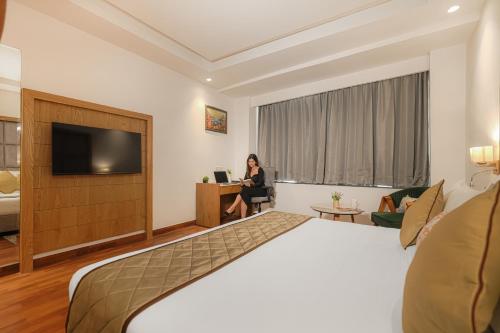 a woman sitting at a desk in a hotel room at Quality Inn Elite Levelup Boutique in Amritsar