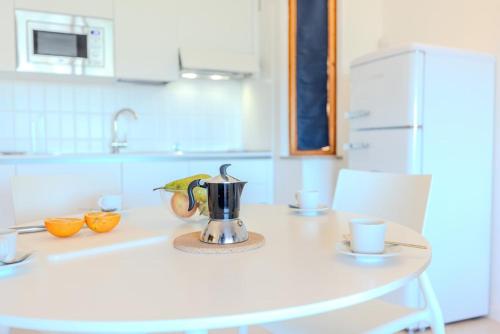 a kitchen with a table with a coffee pot on it at Seafront House Bamba - Sea view and Nature in Capo Coda Cavallo