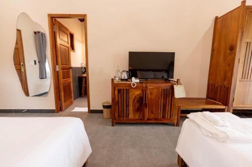 a hotel room with two beds and a television at Le Palmier Long An Boutique Resort - Free Outdoor Cinema in Ấp Kế Mỹ
