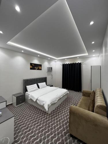 a large bedroom with a bed and a couch at Yaqoot Al Madina Suites in Al ‘Awālī