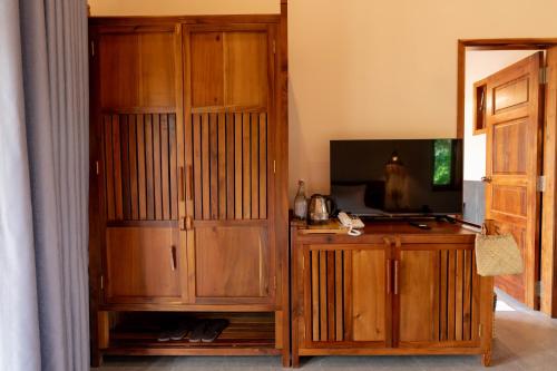 a living room with a tv and a wooden entertainment center at Le Palmier Long An Boutique Resort - Free Outdoor Cinema in Ấp Kế Mỹ