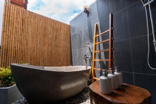 a bath tub in a bathroom with a fence at Le Palmier Long An Boutique Resort - Free Outdoor Cinema in Ấp Kế Mỹ