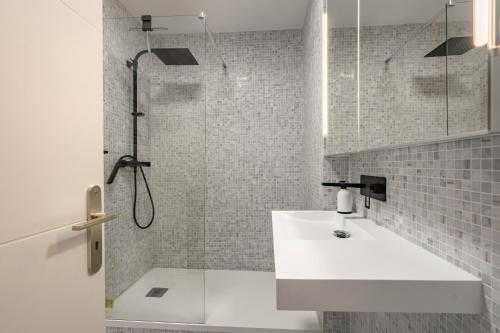 une salle de bain avec un lavabo blanc et une douche dans l'établissement La Résidence des deux Plages, à Saint-Georges-de-Didonne