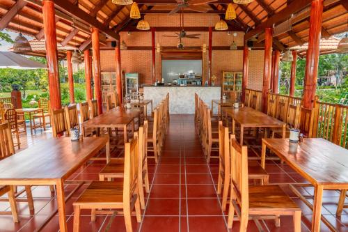 an empty restaurant with wooden tables and chairs at Le Palmier Long An Boutique Resort - Free Outdoor Cinema in Ấp Kế Mỹ