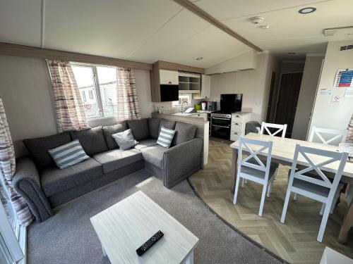 a living room with a couch and a table at Dainville Caravan Park in Skegness