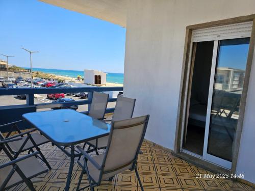 a table and chairs on a balcony with a view of the beach at Blife Ceriya private apartment in Faro
