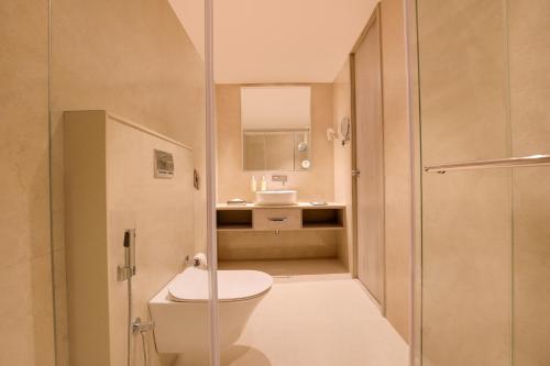 a bathroom with a toilet and a sink at Lemon Tree Hotel, Jamnagar in Jamnagar