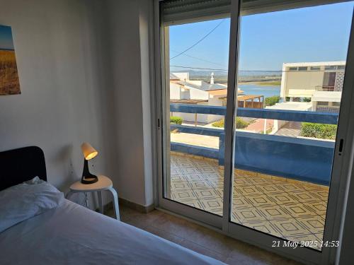 a bedroom with a bed and a view of a balcony at Blife Ceriya private apartment in Faro