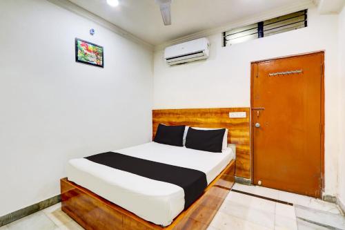 Un dormitorio con una cama y una puerta de madera. en Hotel O Hotel New Hitech Inn, en Hyderabad
