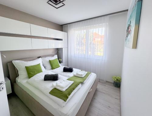 a bedroom with a large bed with green pillows at TemOro Apartman Green in Siófok