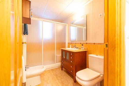 Un baño con inodoro, lavabo y espejo. en Playa de Levante, Céntrico y Parking - by Aloha Palma, en Águilas