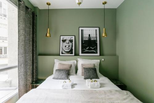 - une chambre avec des murs verts et un lit avec 2 serviettes dans l'établissement Marvelous 2 bedrooms - Saint Honore - Palais Royal, à Paris