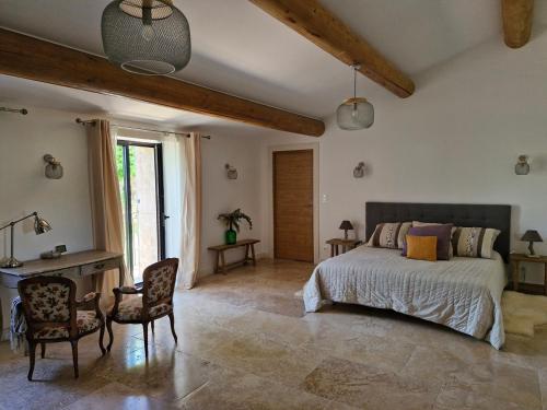 une chambre avec un lit, un bureau et des chaises dans l'établissement Mas Romainho, Luxe et Charme à St Rémy, à Saint-Rémy-de-Provence