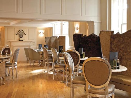 a dining room with tables and chairs and a couch at The Spread Eagle Hotel in Thame