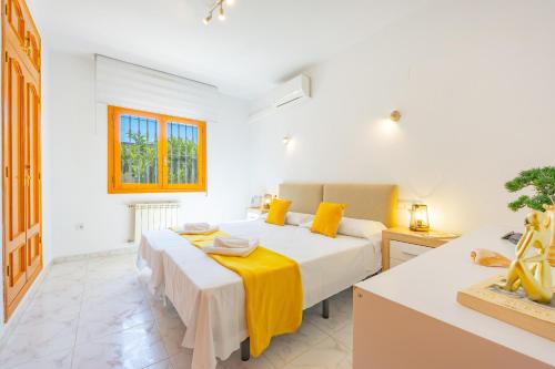 a white bedroom with two beds and a window at Villa Mona - PlusHolidays in Ifach