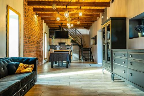 salon z kanapą i kuchnią w obiekcie Na Zakręcie - Domek Loft w mieście Błędowo