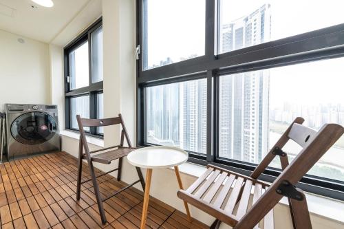two chairs and a table in a room with windows at The November Stay In landmark in Incheon