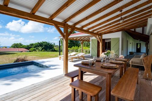 a patio with a table and a pool at Villa Jacaranda in Capesterre-de-Marie-Galante