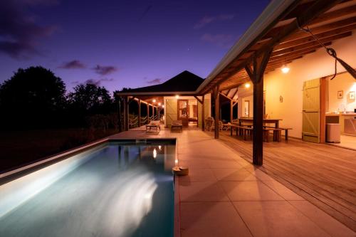a house with a swimming pool at night at Villa Jacaranda in Capesterre-de-Marie-Galante