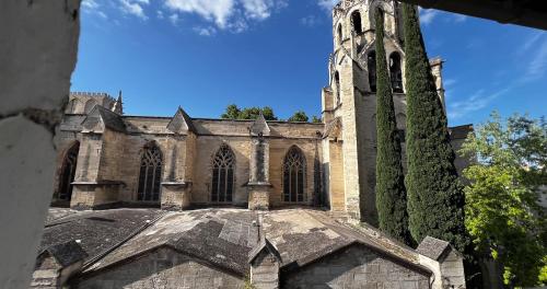une ancienne église avec une tour et un bâtiment dans l'établissement Hypercentre - Exceptional rooftop view!, à Avignon