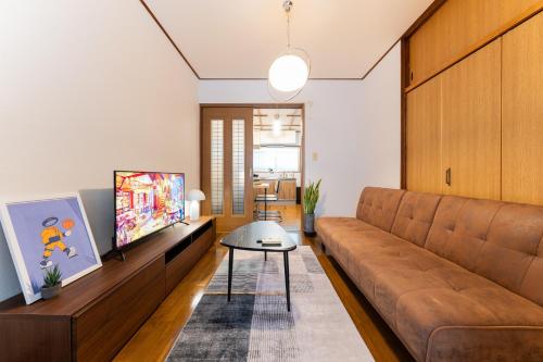 a living room with a couch and a tv at Animal Art Apartment Type 12 in Tokyo