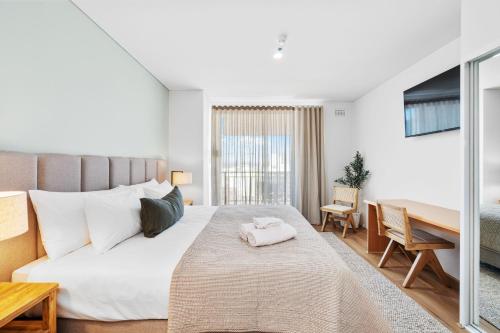 a bedroom with a bed and a table and a desk at Cityscape Haven Victoria Retreat, Perth Cbd in Perth