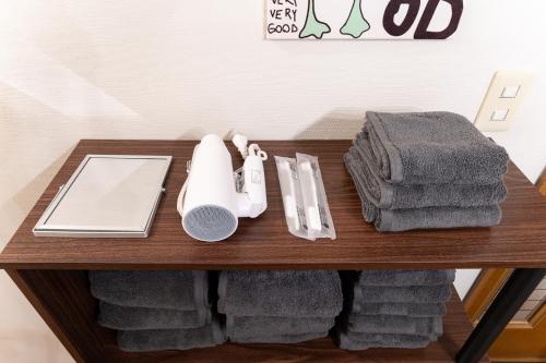 einem Holztisch mit Handtüchern und einer Fernbedienung in der Unterkunft Animal Art Apartment Type 12 in Tokio