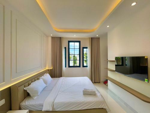 a bedroom with a bed and a flat screen tv at DCAO Villas Novaworld Phan Thiet in Bình Tú