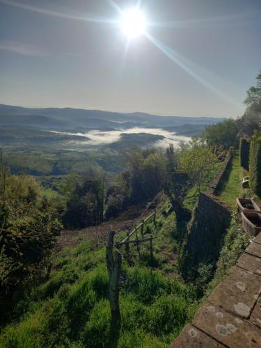 a person standing on a hill with the sun in the sky at Autenticum Agriturismo Tolfa in Tolfa