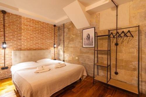 une chambre avec un lit et un mur de briques dans l'établissement Industrial loft - Le Marais - Bastille, à Paris