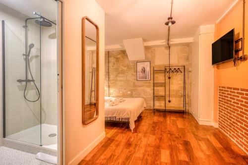 Cette chambre comprend un lit et une salle de bains pourvue d'une douche. dans l'établissement Industrial loft - Le Marais - Bastille, à Paris